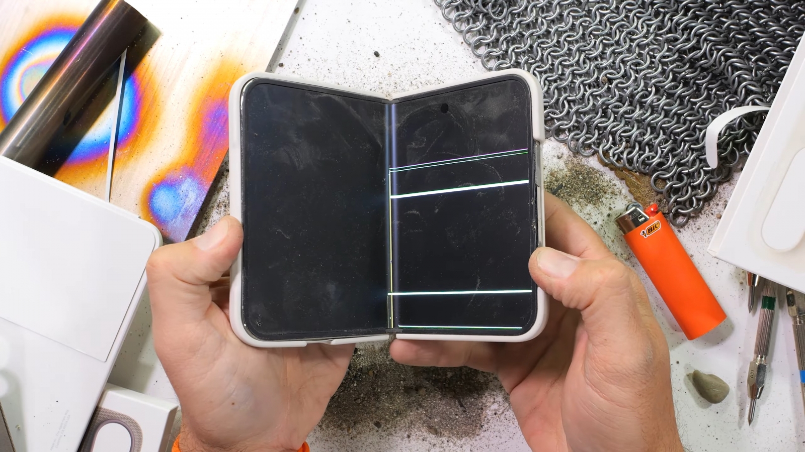 iPhone Duo during a foldable-phone durability test focused on the hinge and inner display.